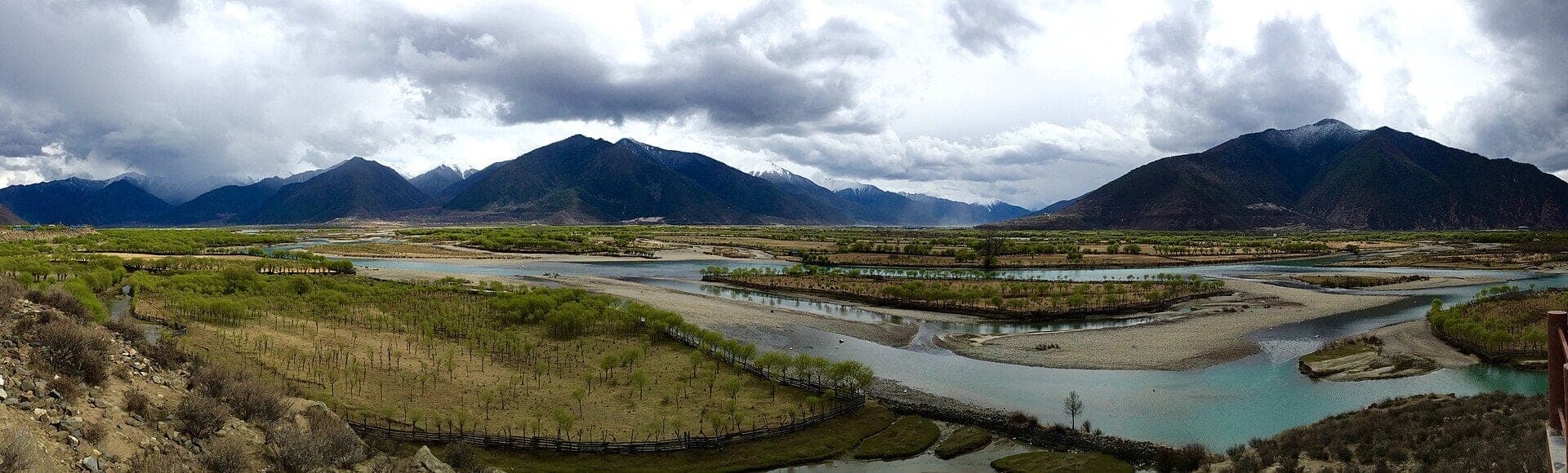 The braided Yarlung Tsangpo river beneath forested mountains near Nyingchi